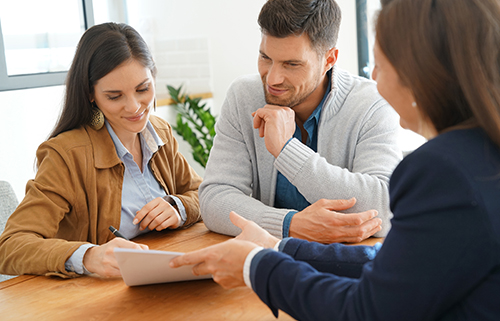 Couple meeting financial adviser for home investment contract